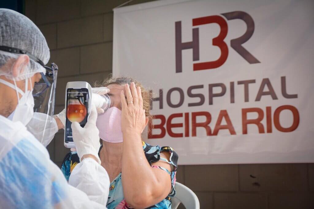 Mulher sendo examinada no mutirão de Itabuna/BA por um Retinógrafo Portátil Eyer da Phelcom Technologies.