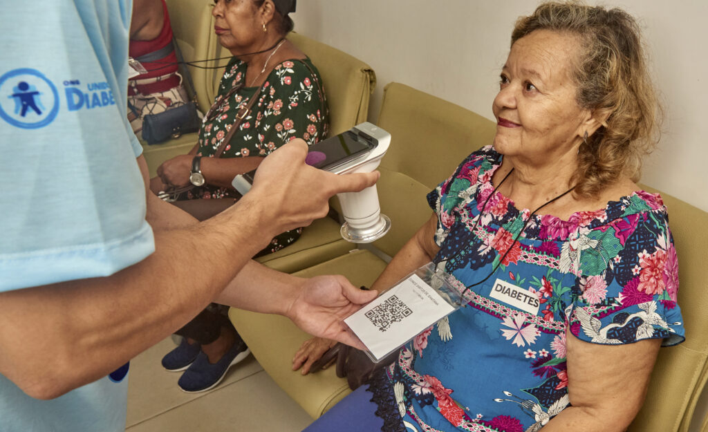 Com Eyer, voluntária faz leitura de QRCode com informações da paciente durante o Mutirão do Diabetes de Itabuna.